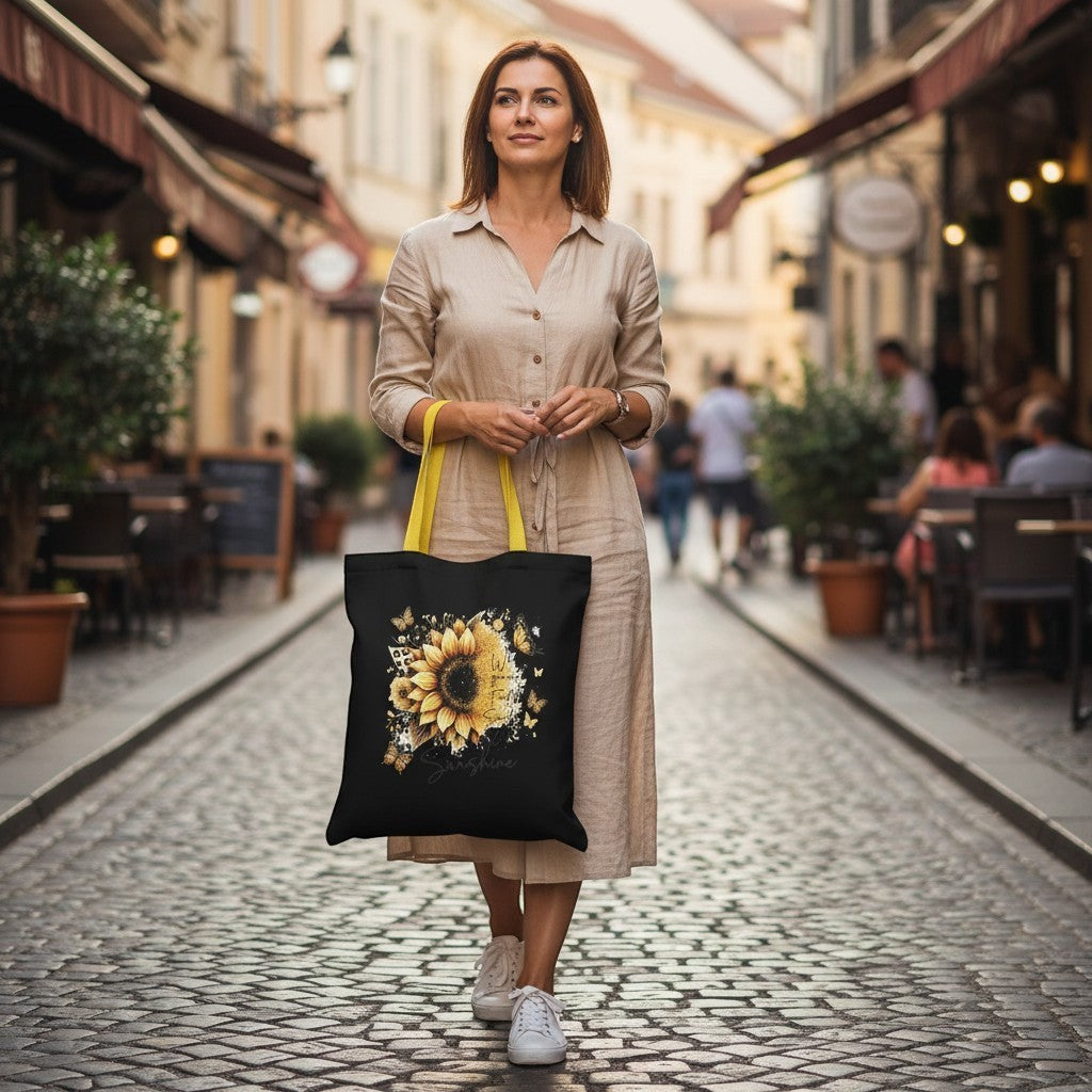 Woman walking down a street holding a black tote bag with a sunflower design.