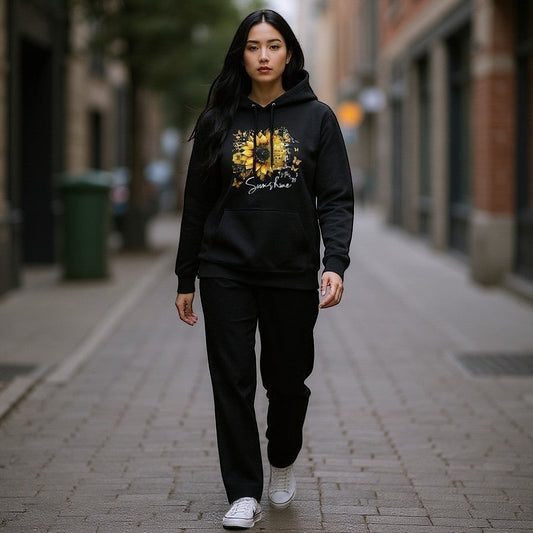 Person wearing a black hoodie with a sunflower design on a city street