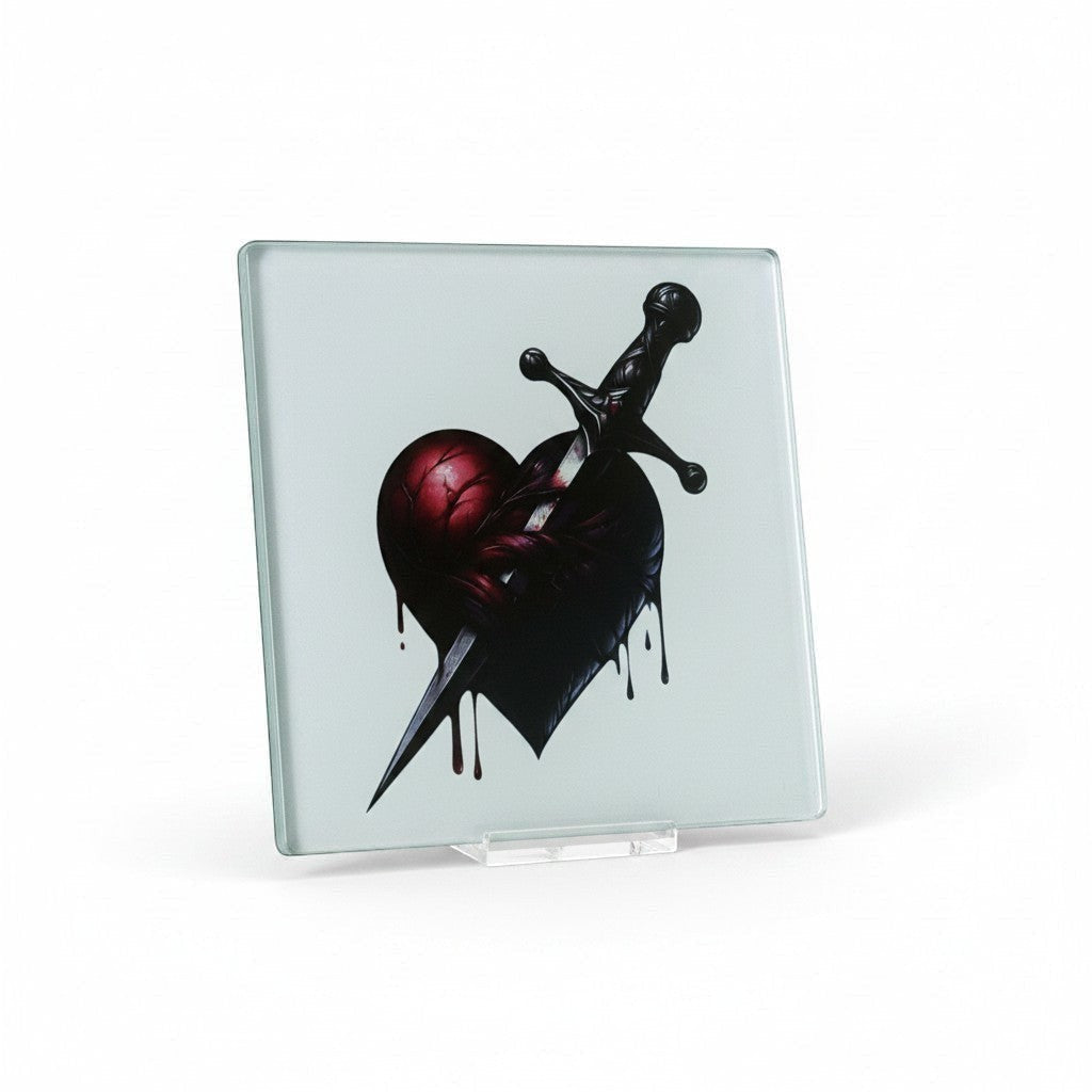 Illustrated Solutions Store gothic glass coaster with a dark red heart pierced by a black dagger, dripping blood.