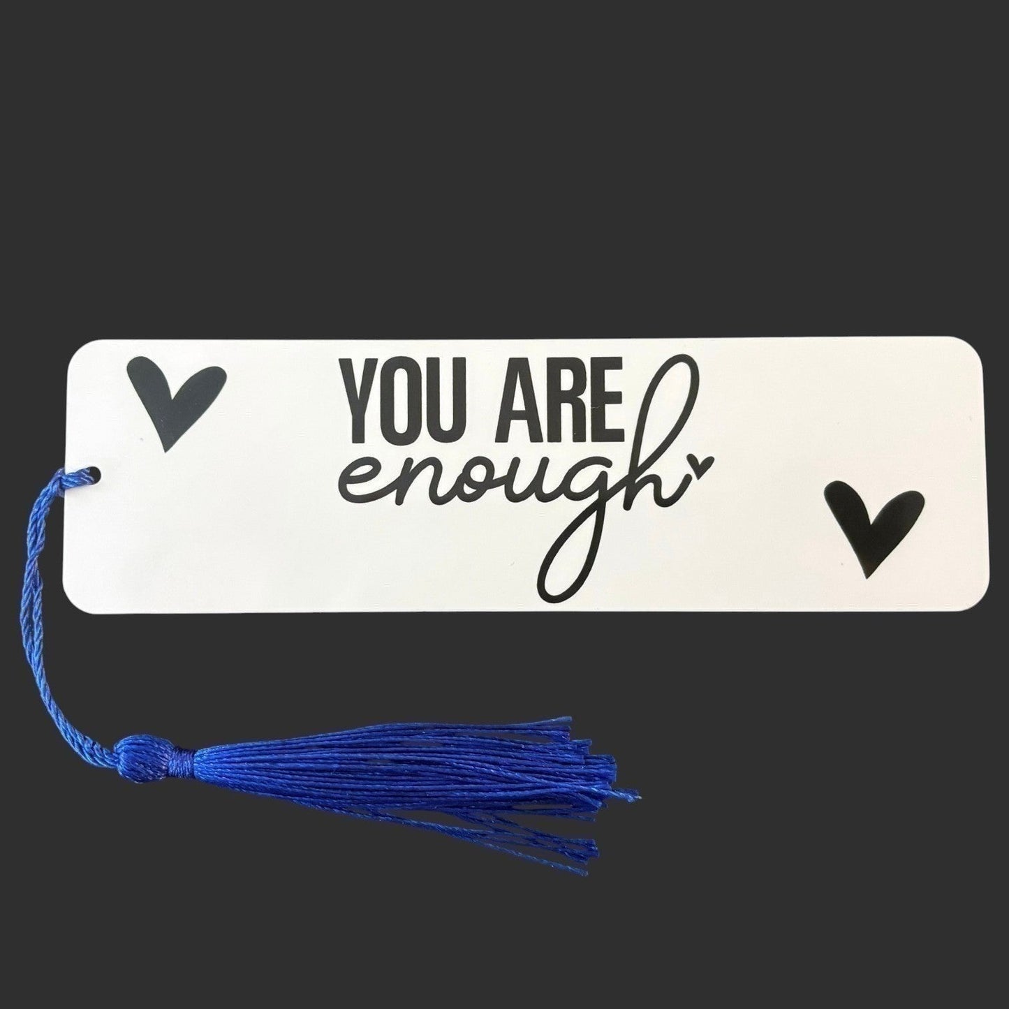 Illustrated Solutions Store metal bookmark with You Are Enough text and blue tassel on a white background
