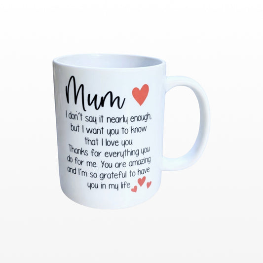 Illustrated Solutions Store white ceramic mug with black text reading "Mum I don't say it nearly enough, but I want you to know that I love you. Thanks for everything you do for me. You are amazing and I'm so grateful to have you in my life." and red heart accents.