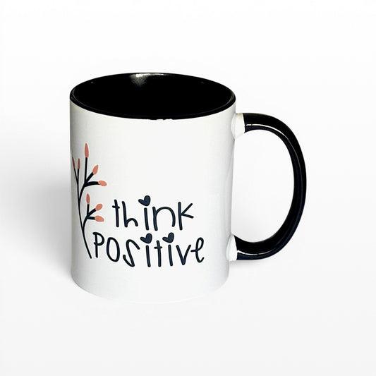 Illustrated Solutions Store white ceramic mug with black interior and handle, featuring the text "think POSITIVE" and a delicate floral branch.