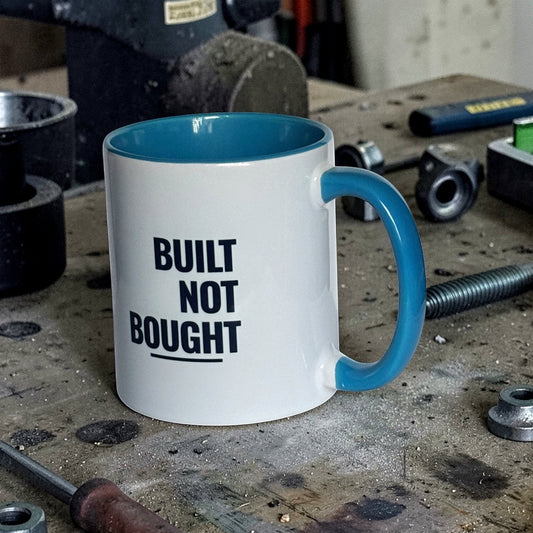 Built Not Bought car enthusiast light blue mug front view on workshop table
