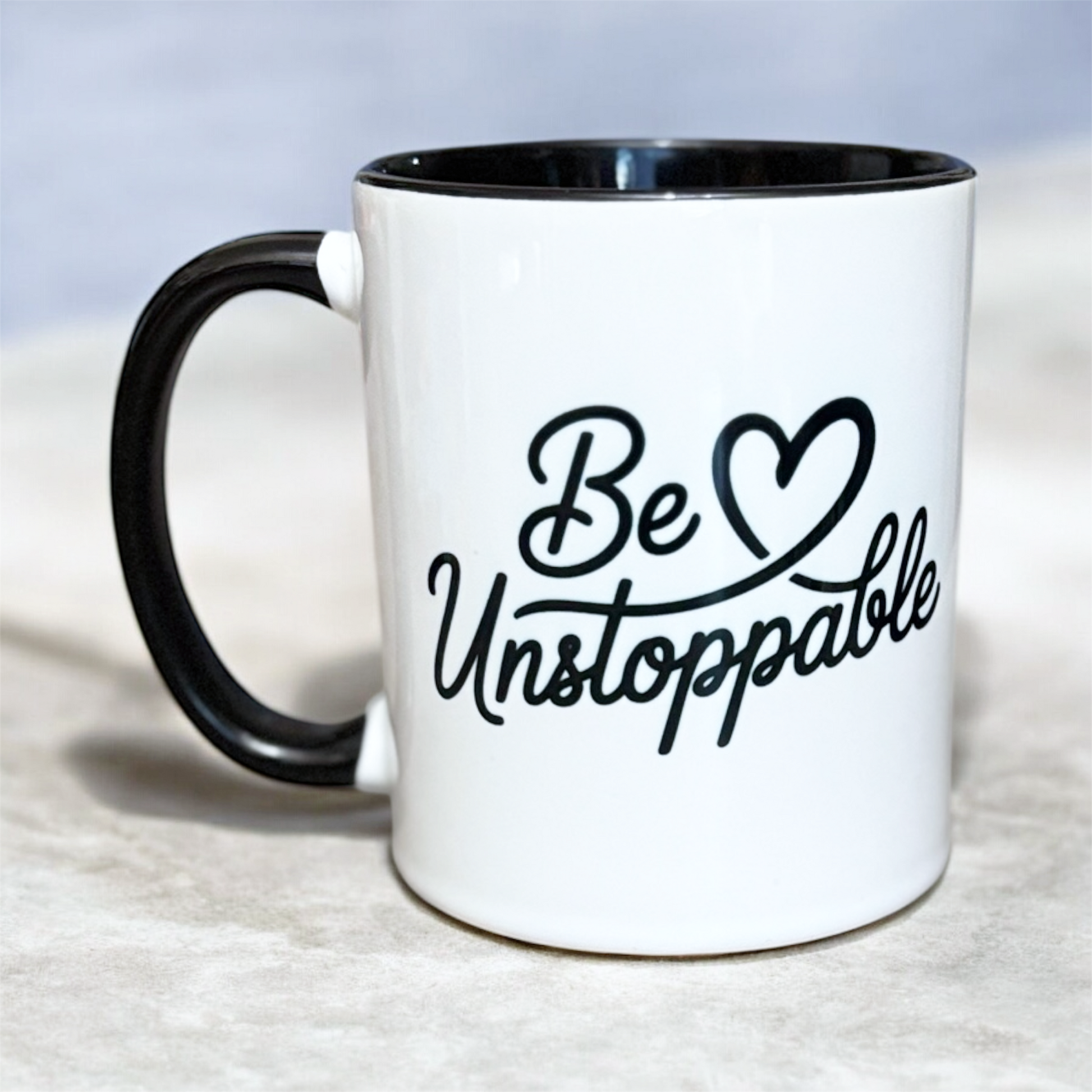 White ceramic mug with black interior and handle featuring Be Unstoppable motivational design hand printed UK
