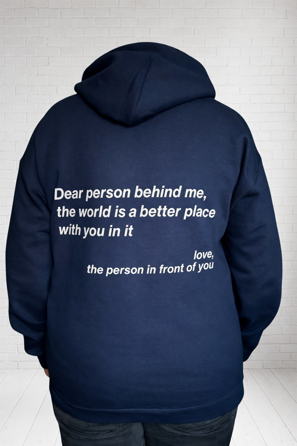 Navy blue hoodie with a motivational message on the back, worn by a person. Printed and pressed by hand in the UK