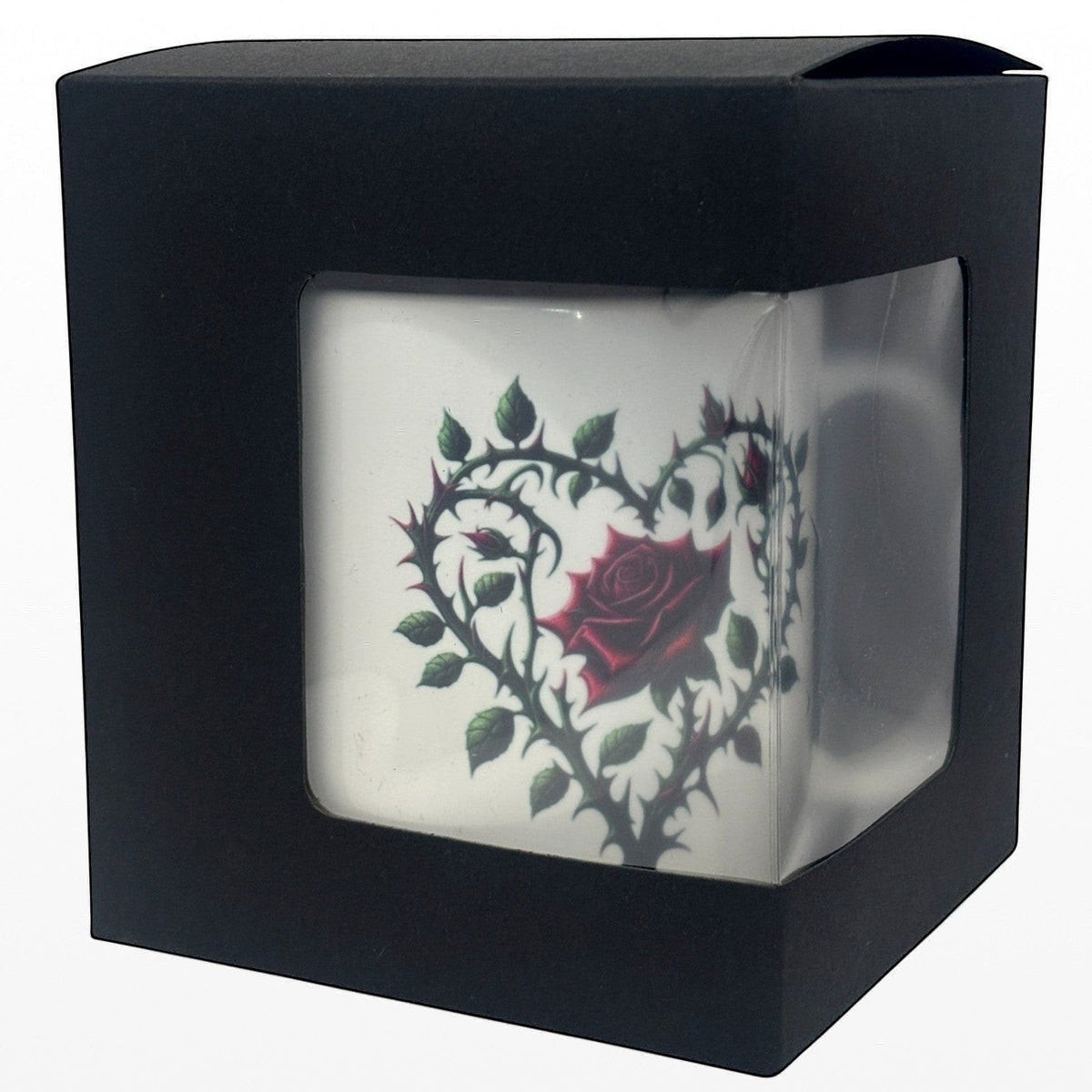 Black box with a clear front displaying a white mug with a red rose design.