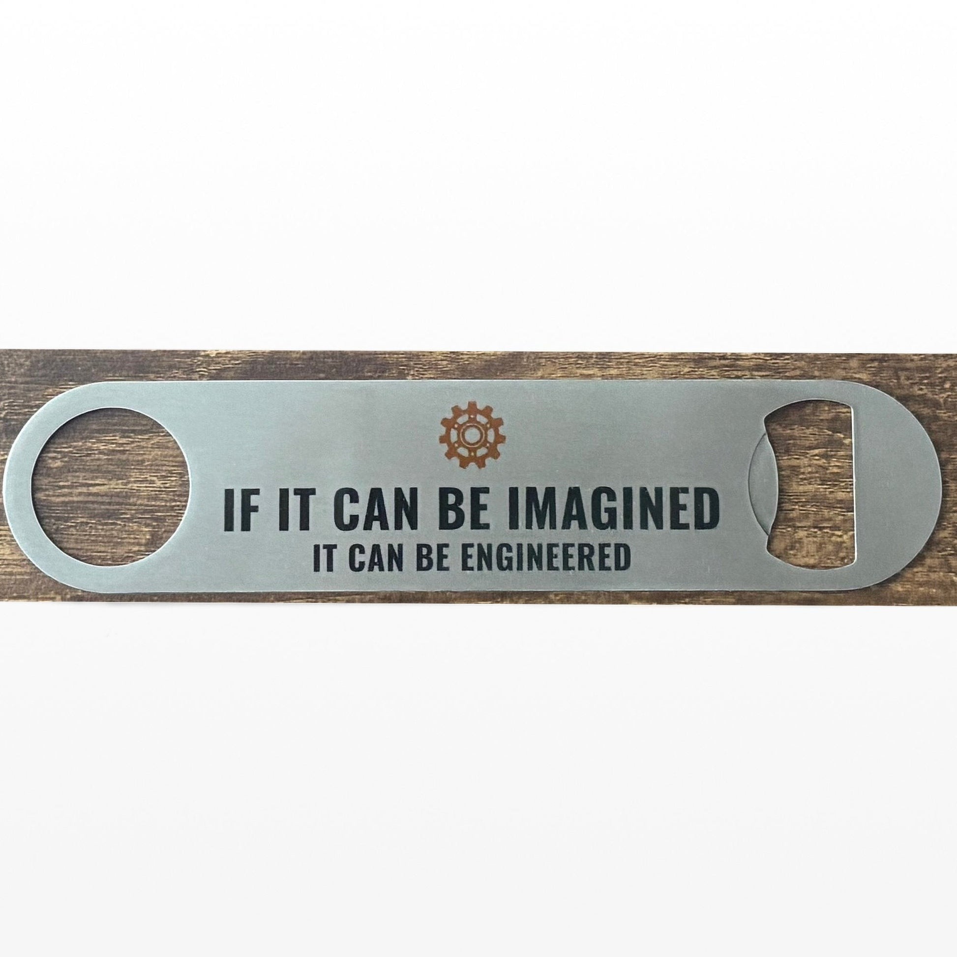Stainless Steel Bar Blade with Steampunk Cog and If It Can Be Imagined Text in black. Bar blade on wooden table.