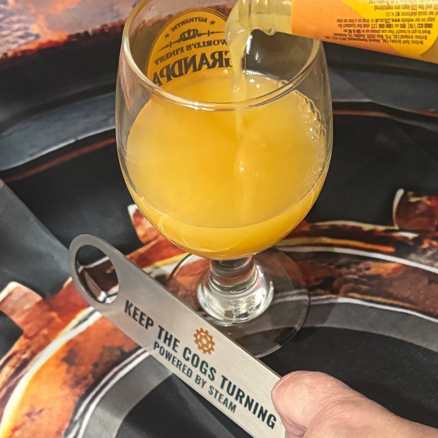 Stainless Steel Bar Blade with Steampunk Cog with drink poured alongside bar blade