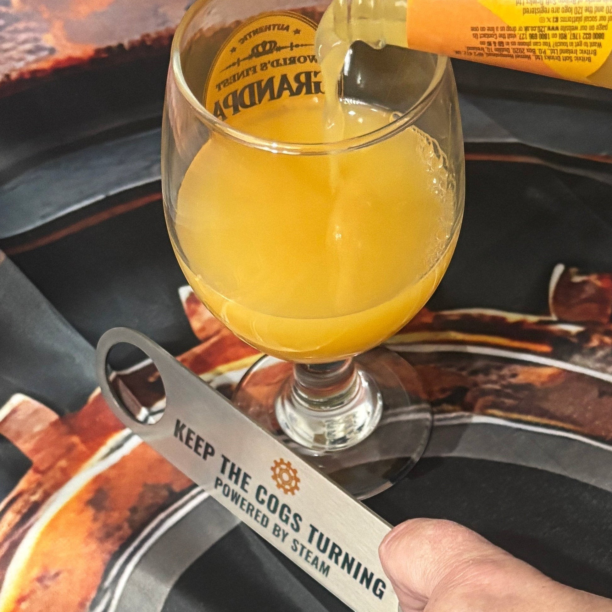 Stainless Steel Bar Blade with Steampunk Cog with drink poured alongside bar blade