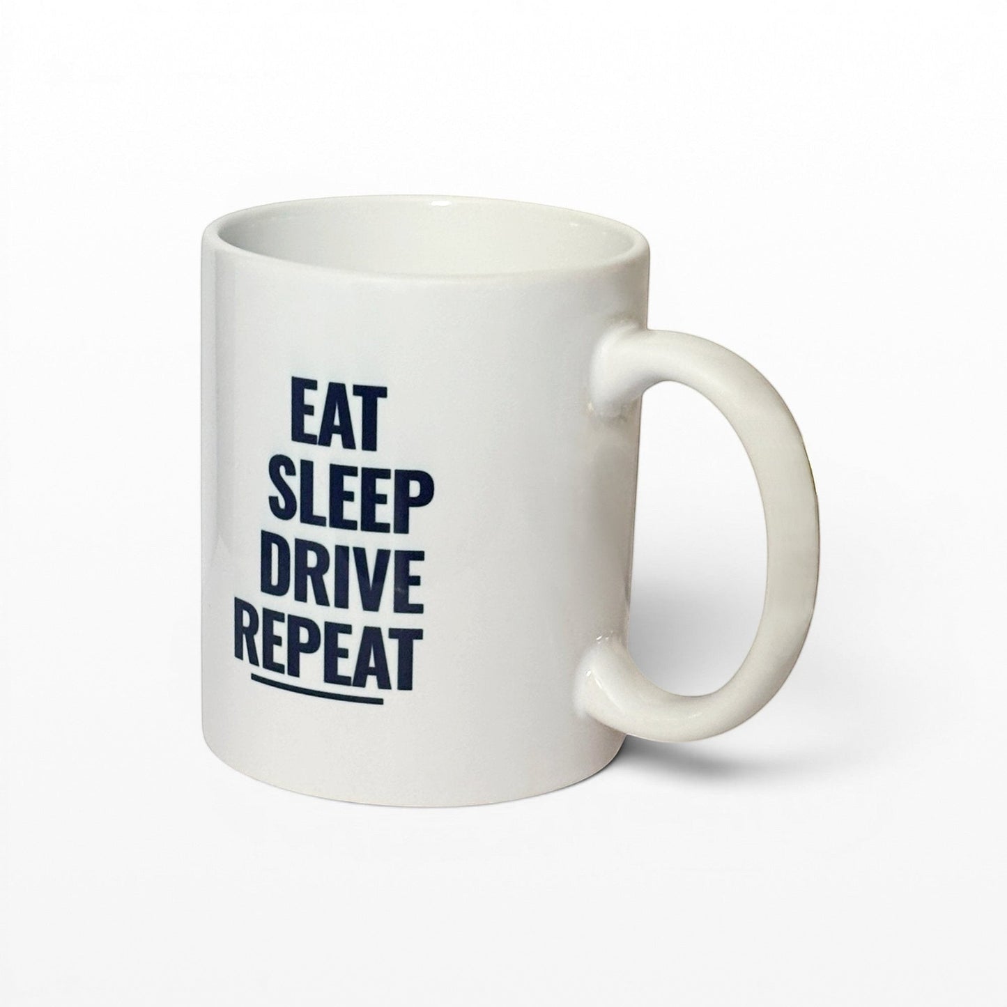 White mug with 'EAT SLEEP DRIVE REPEAT' text on a grey background