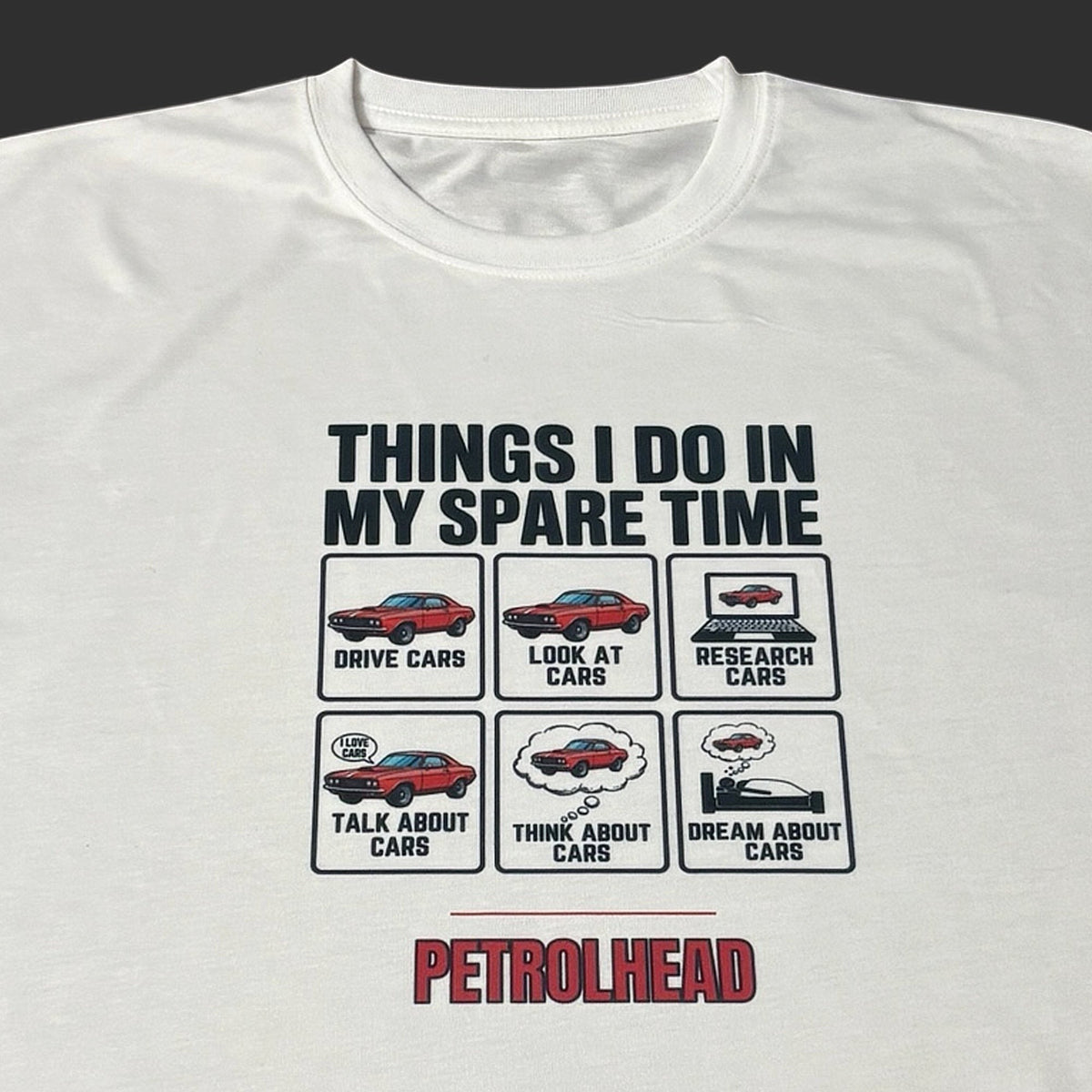 Close up view of white t-shirt with car-themed graphic and text for car enthusiasts on a dark background