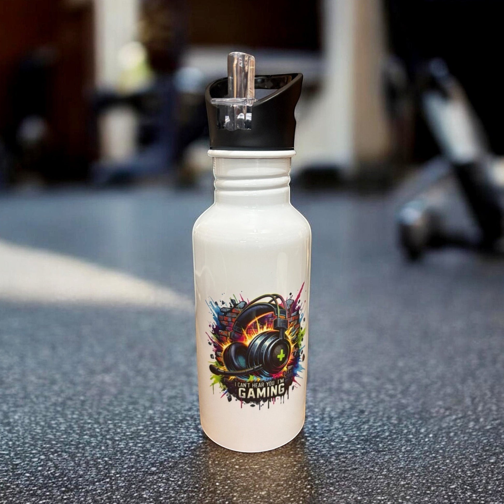 Metal water bottle with gaming design placed on a gym floor