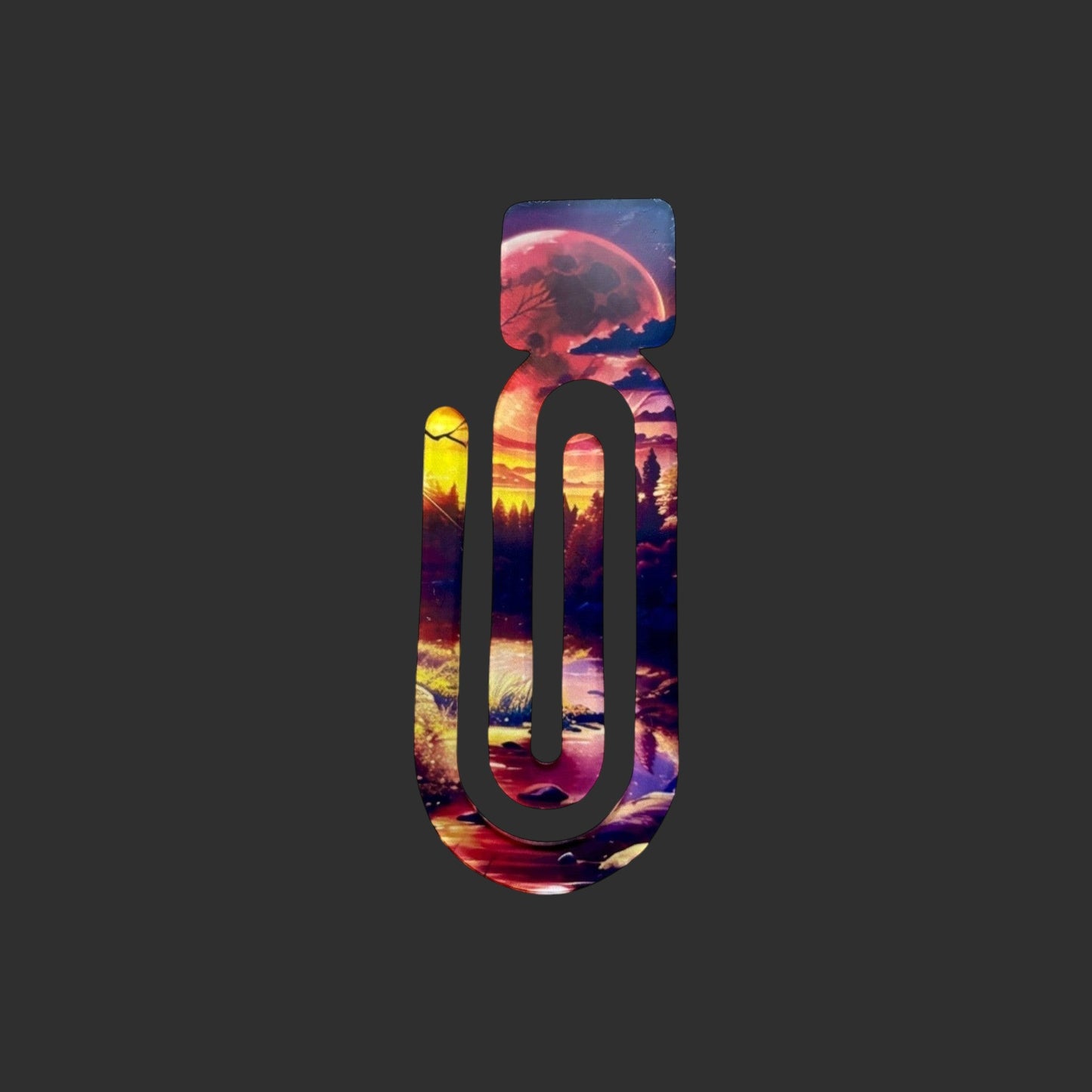 A perfect literary gift of an acrylic book clip featuring a vibrant Into The Woods sunset forest landscape design.