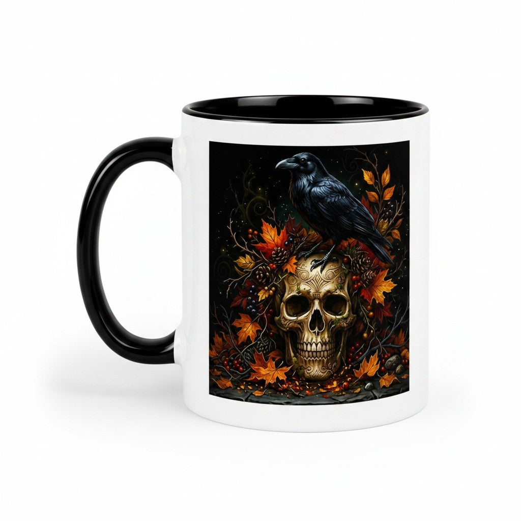 A white ceramic mug with a black handle and black interior, featuring a printed graphic of a black raven perched on a gold skull surrounded by orange autumn leaves and dark berries.