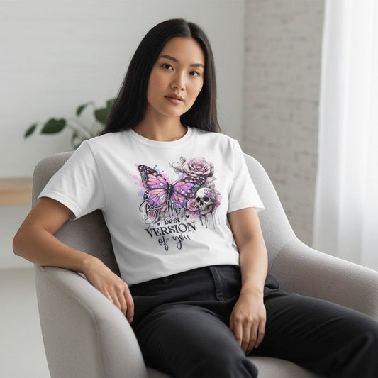 Woman wearing a white t-shirt with a colorful butterfly and floral design, sitting in a chair.