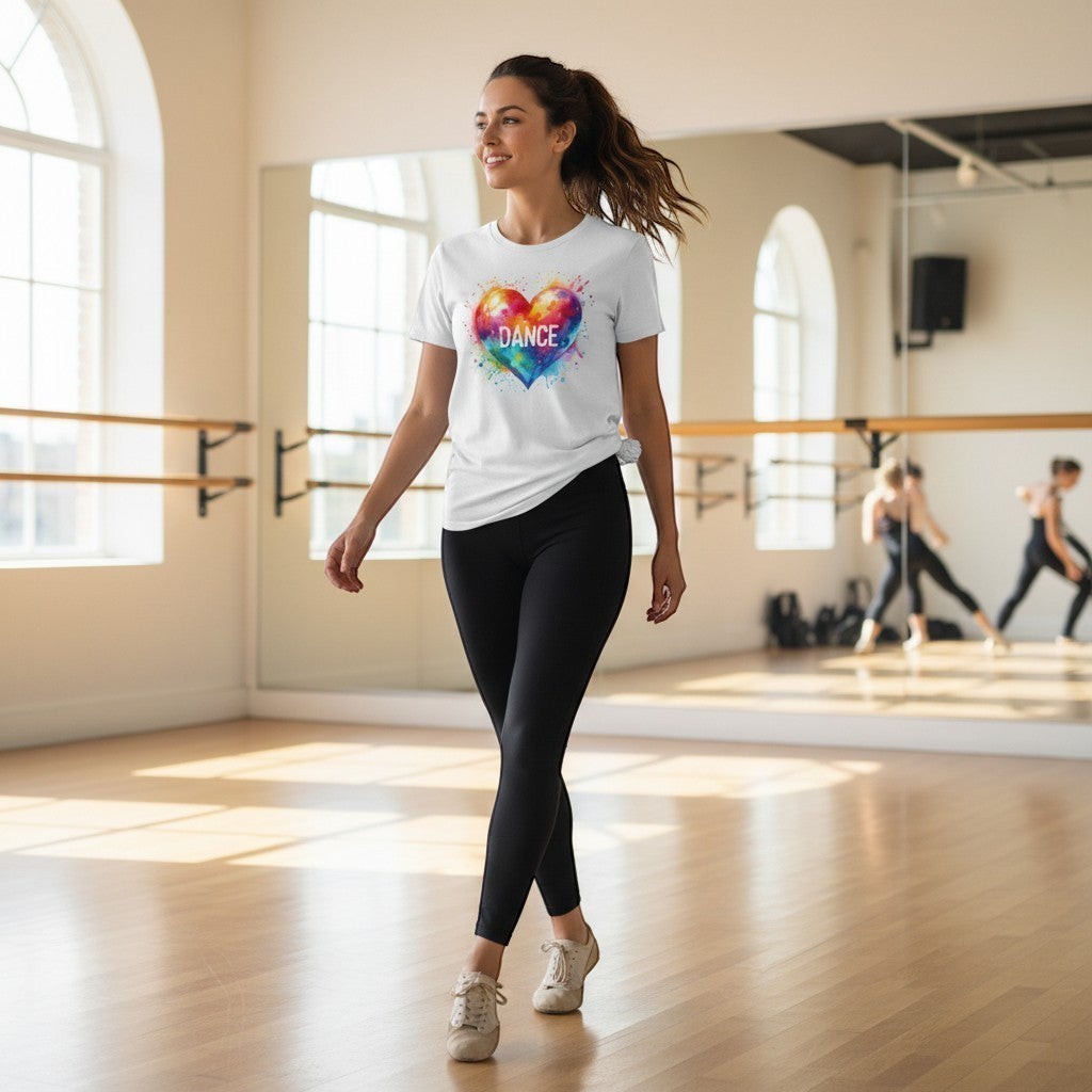 Woman in a dance studio wearing a white t-shirt with a colorful heart design and 'DANCE' text.