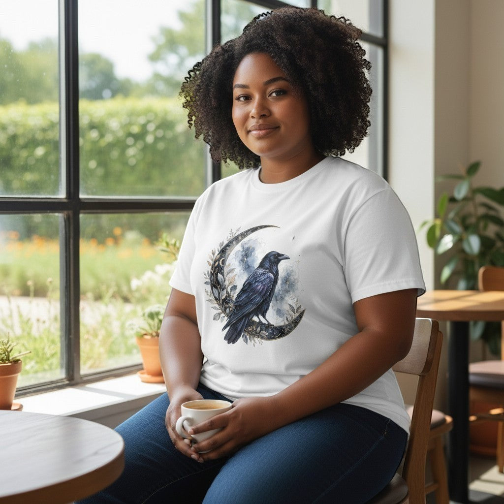 Woman wearing a white t-shirt with a black crow design, sitting in a bright room with large windows.