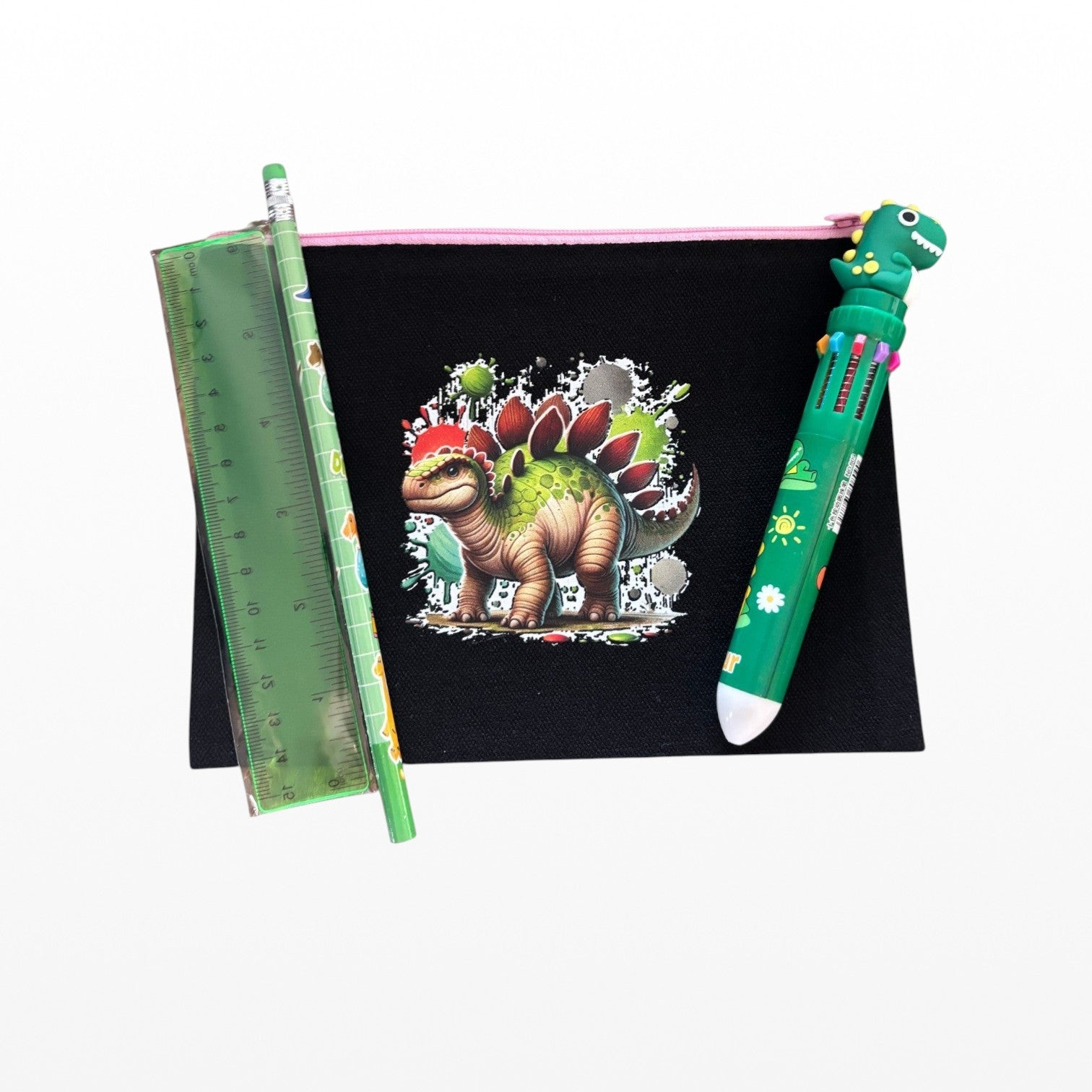 Colorful dinosaur-themed stationery set with a ruler, pen, and notebook on a white background