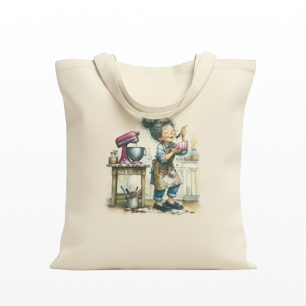 Illustrated Solutions Store cream canvas tote bag with a baking girl illustration, pink stand mixer, and kitchen counter.