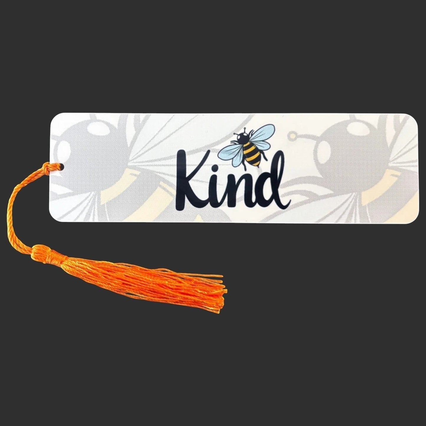 Illustrated Solutions Store metal bookmark with Bee Kind text, bumblebee illustration, and orange tassel.