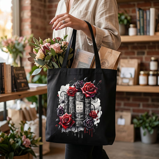 Illustrated Solutions Store black canvas tote bag featuring a gothic book and red rose illustration for book lovers.