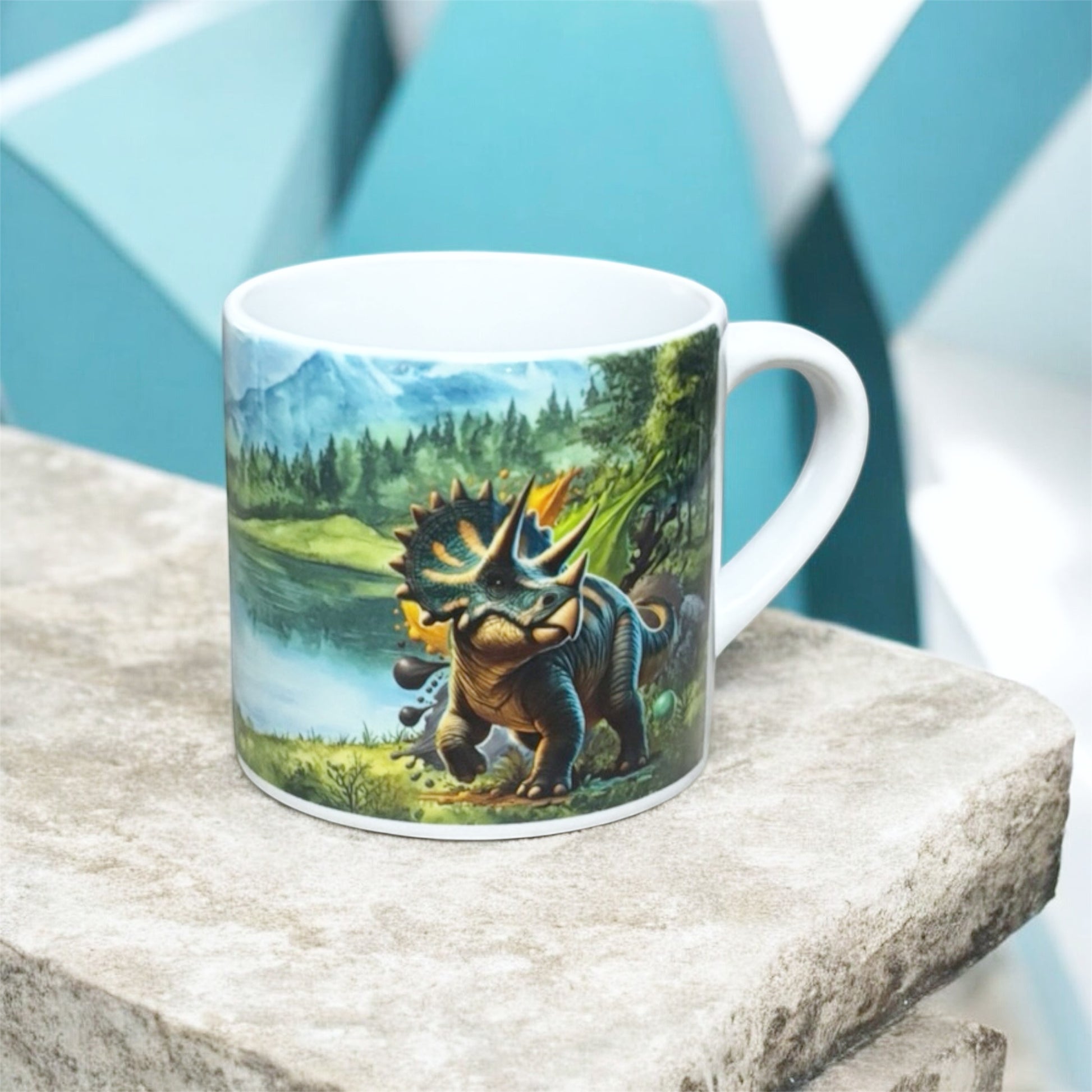 Illustrated Solutions Store kids mug with a vibrant dinosaur landscape design featuring a triceratops by a lake.