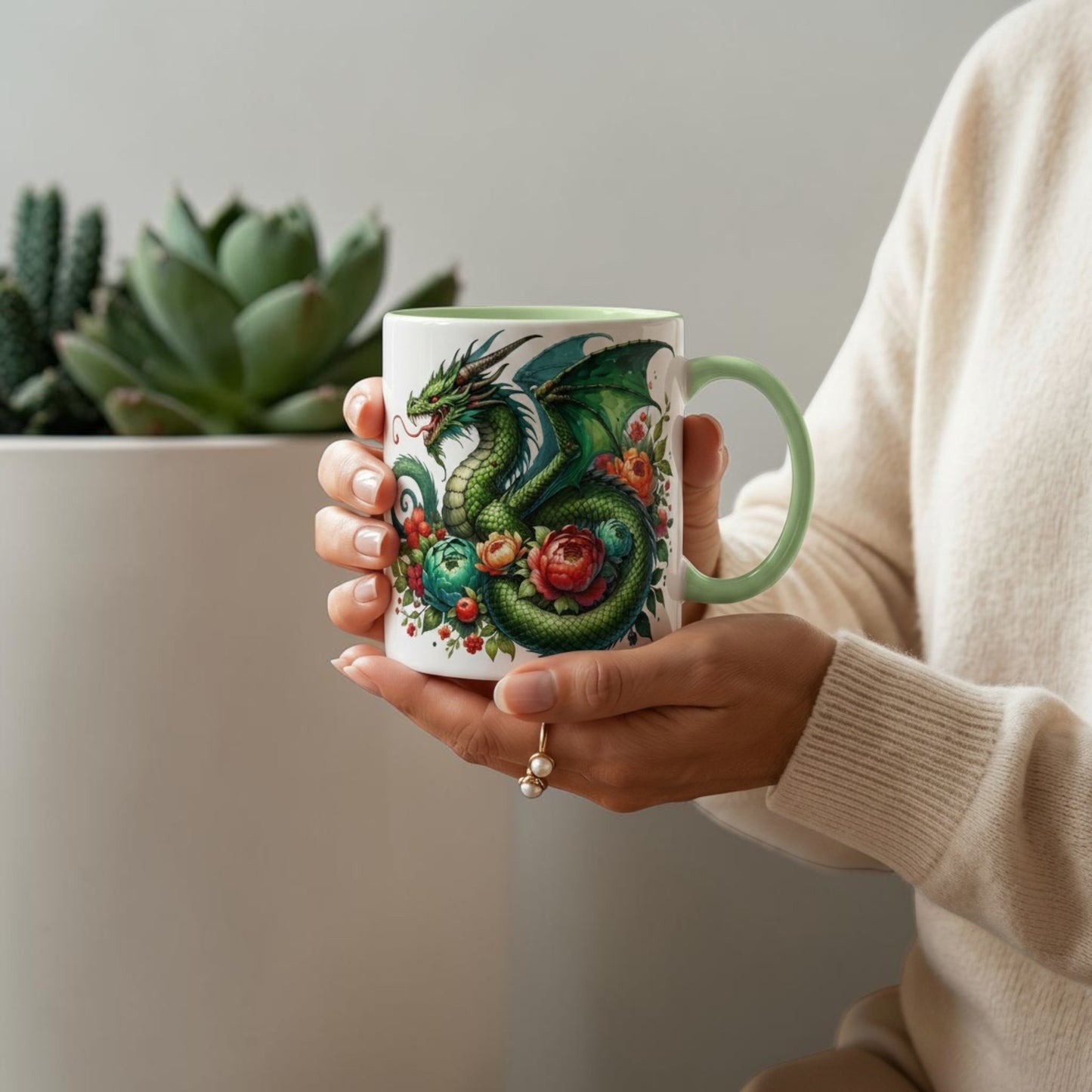 Illustrated Solutions Store 11oz ceramic mug featuring a green dragon and floral design on a light green handled mug held in hands