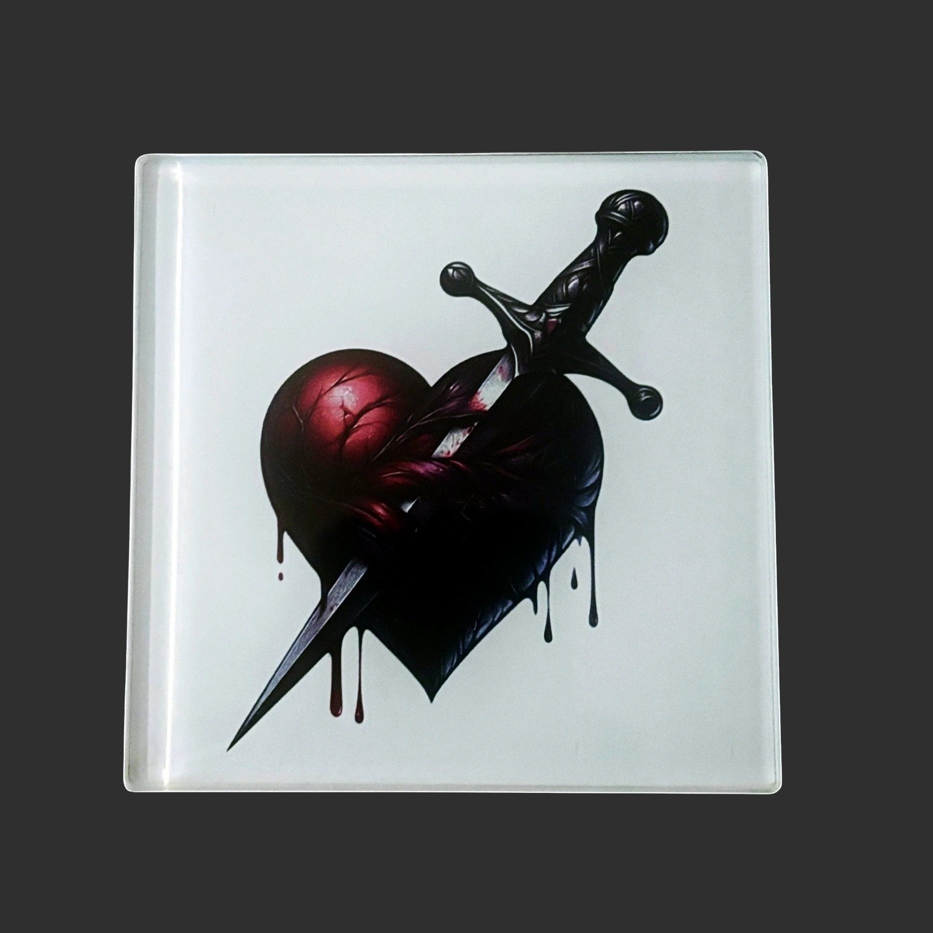 Illustrated Solutions Store gothic heart dagger glass square coaster. Features a dark red heart pierced by a dagger.