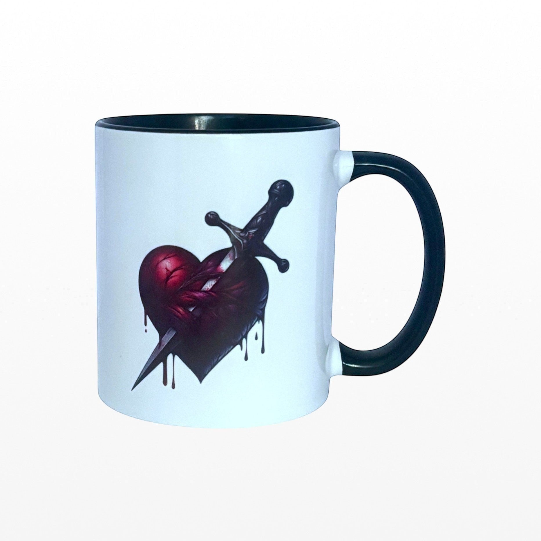 Illustrated Solutions Store white ceramic mug with black handle and interior, featuring a dark gothic heart pierced by a dagger.