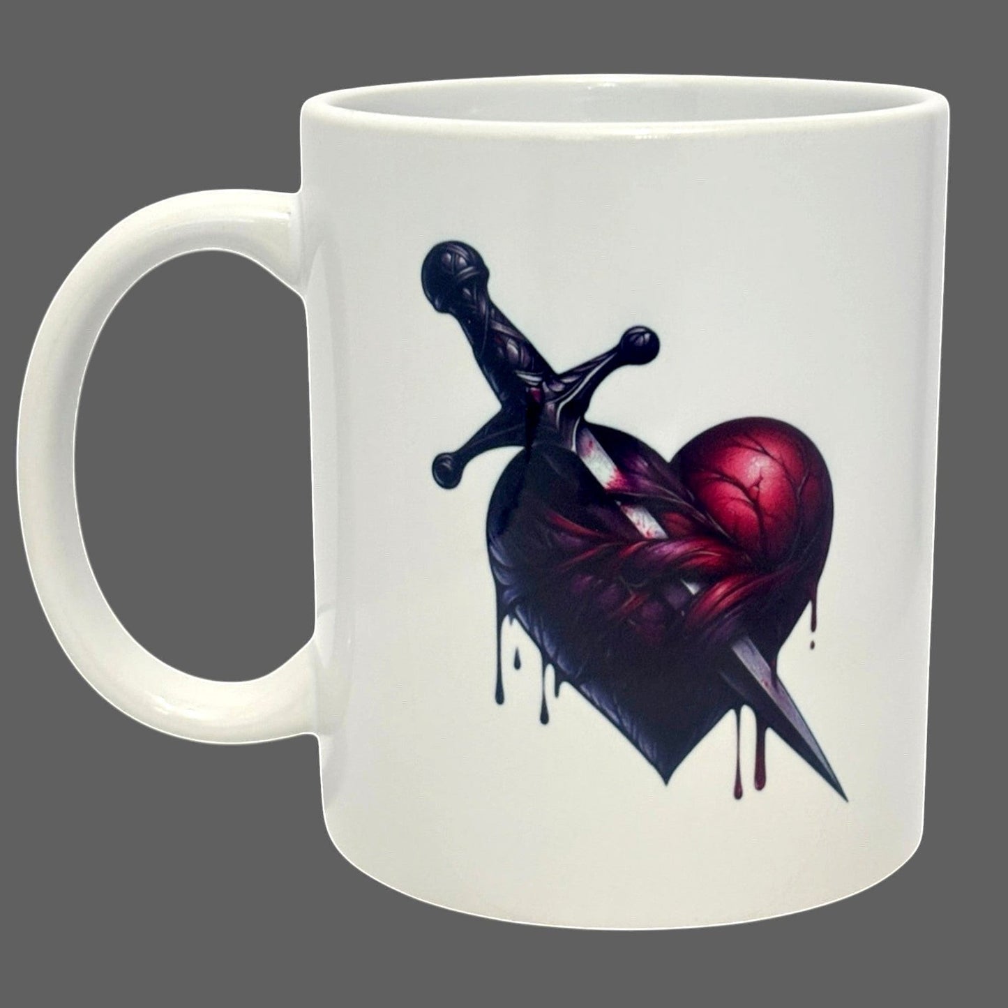 Illustrated Solutions Store white ceramic mug with a dark gothic heart pierced by a dagger design.