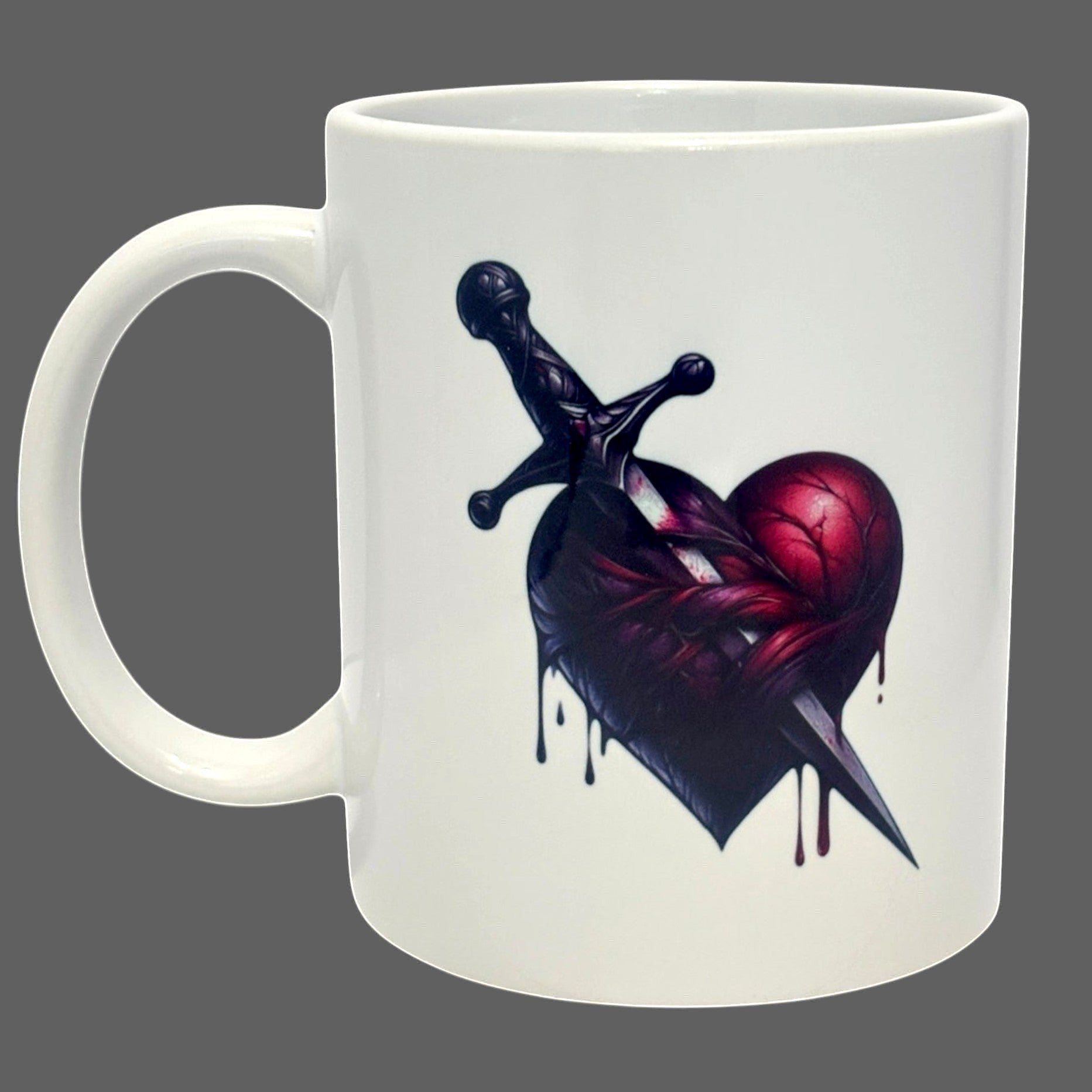 Illustrated Solutions Store white ceramic mug with a dark gothic heart pierced by a dagger design.