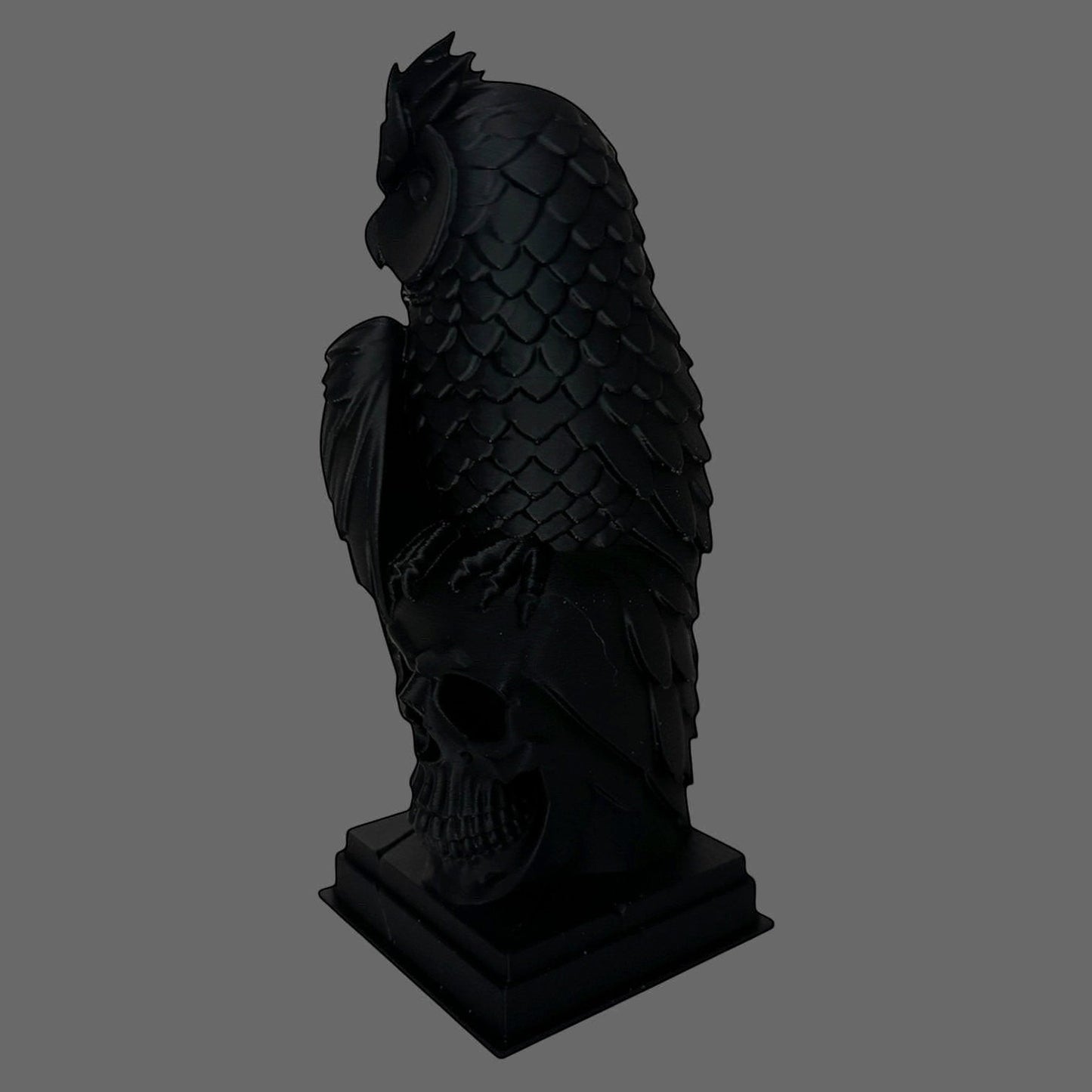 Illustrated Solutions Store black gothic owl figurine perched on a detailed skull base, featuring layered feather detail and a strong silhouette.