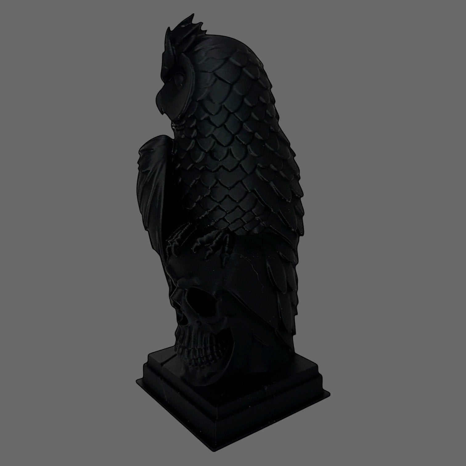 Illustrated Solutions Store black gothic owl figurine perched on a detailed skull base, featuring layered feather detail and a strong silhouette.