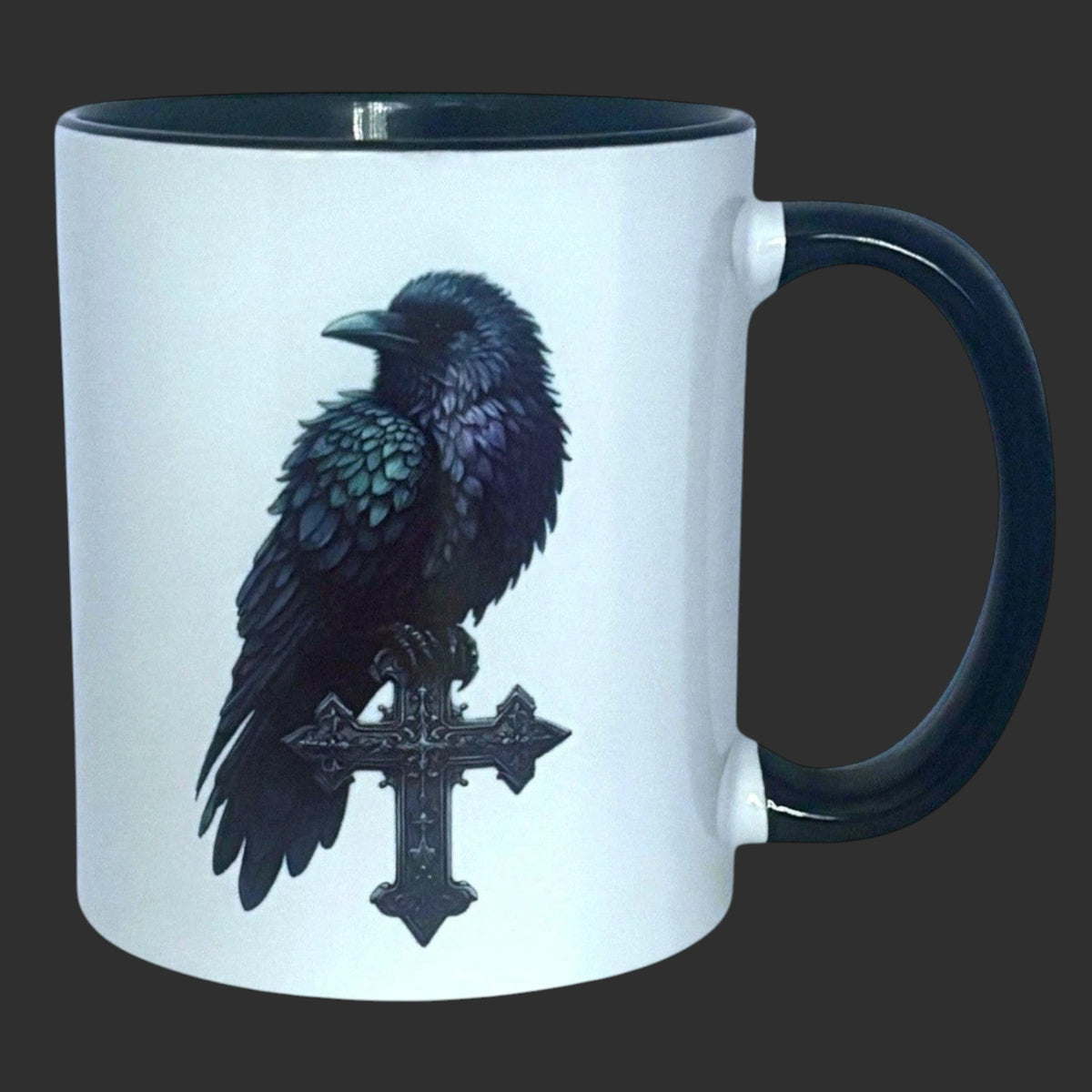 Illustrated Solutions Store white ceramic mug with black handle, featuring a detailed gothic raven perched on a black cross.