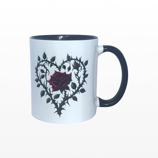 Illustrated Solutions Store white ceramic mug with dark grey handle and rim, featuring a gothic heart design with a red rose and thorny vines.