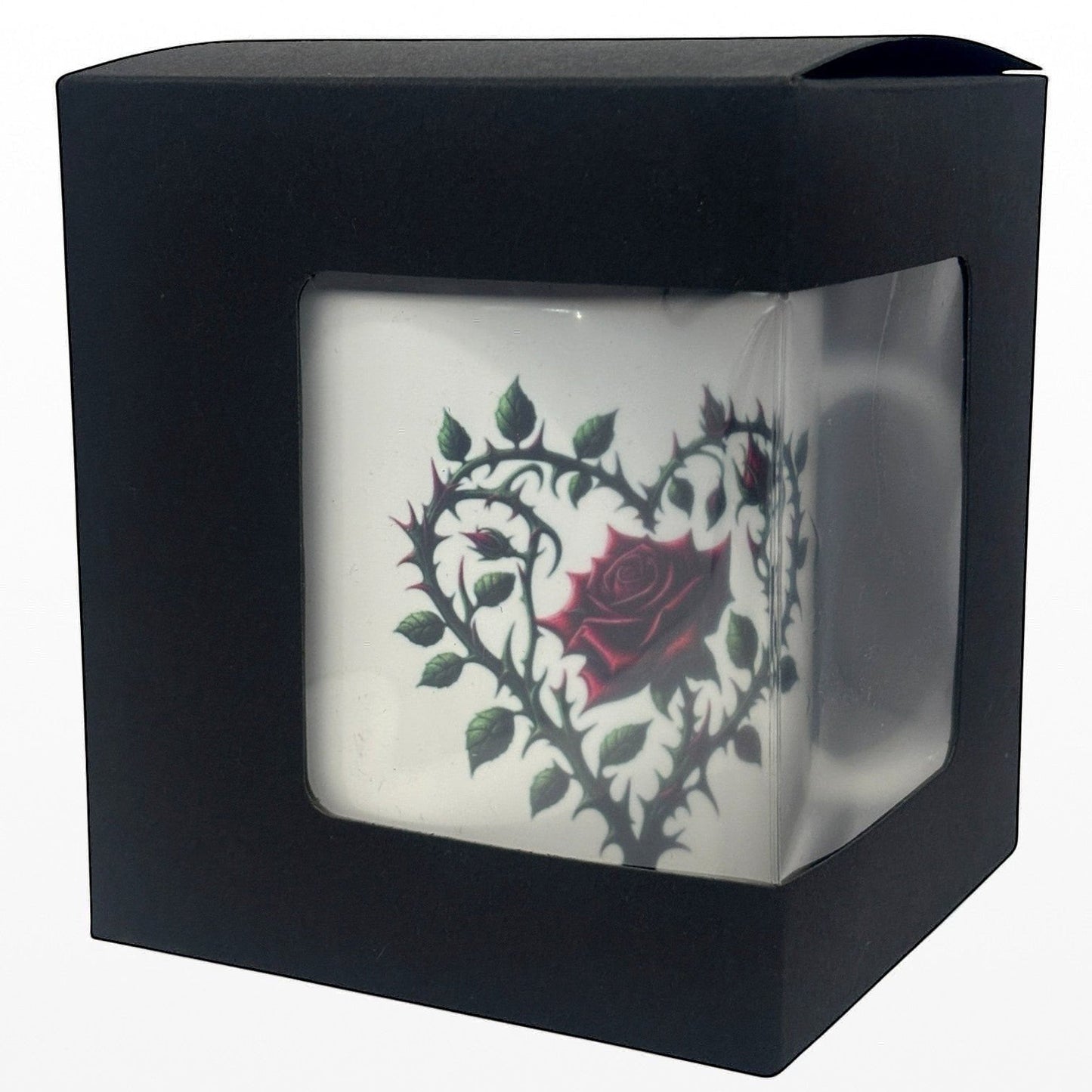 Black box with a clear front displaying a white mug with a red rose design.