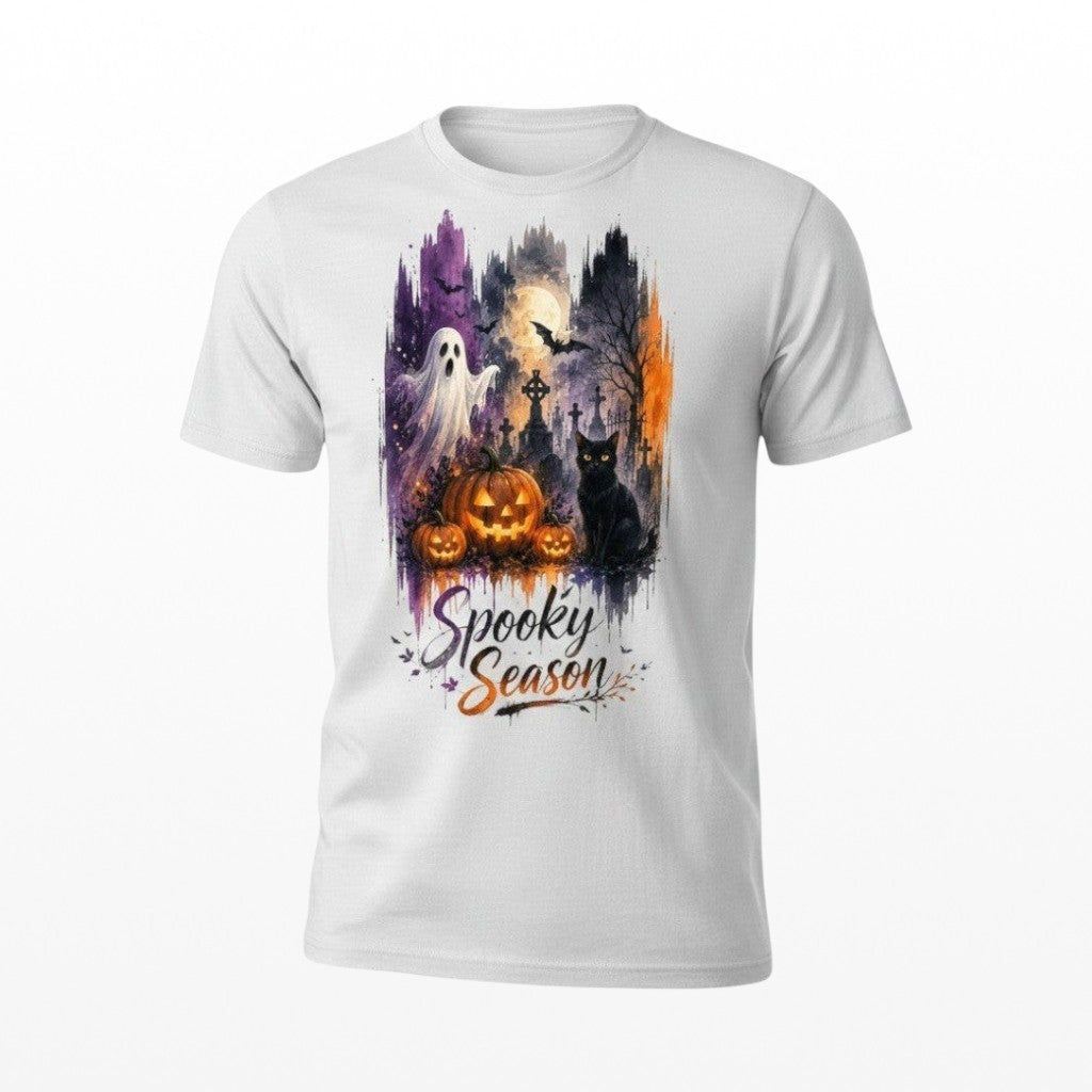 Illustrated Solutions Store white unisex T-shirt with a spooky Halloween graveyard, ghost, cat, and pumpkin graphic.