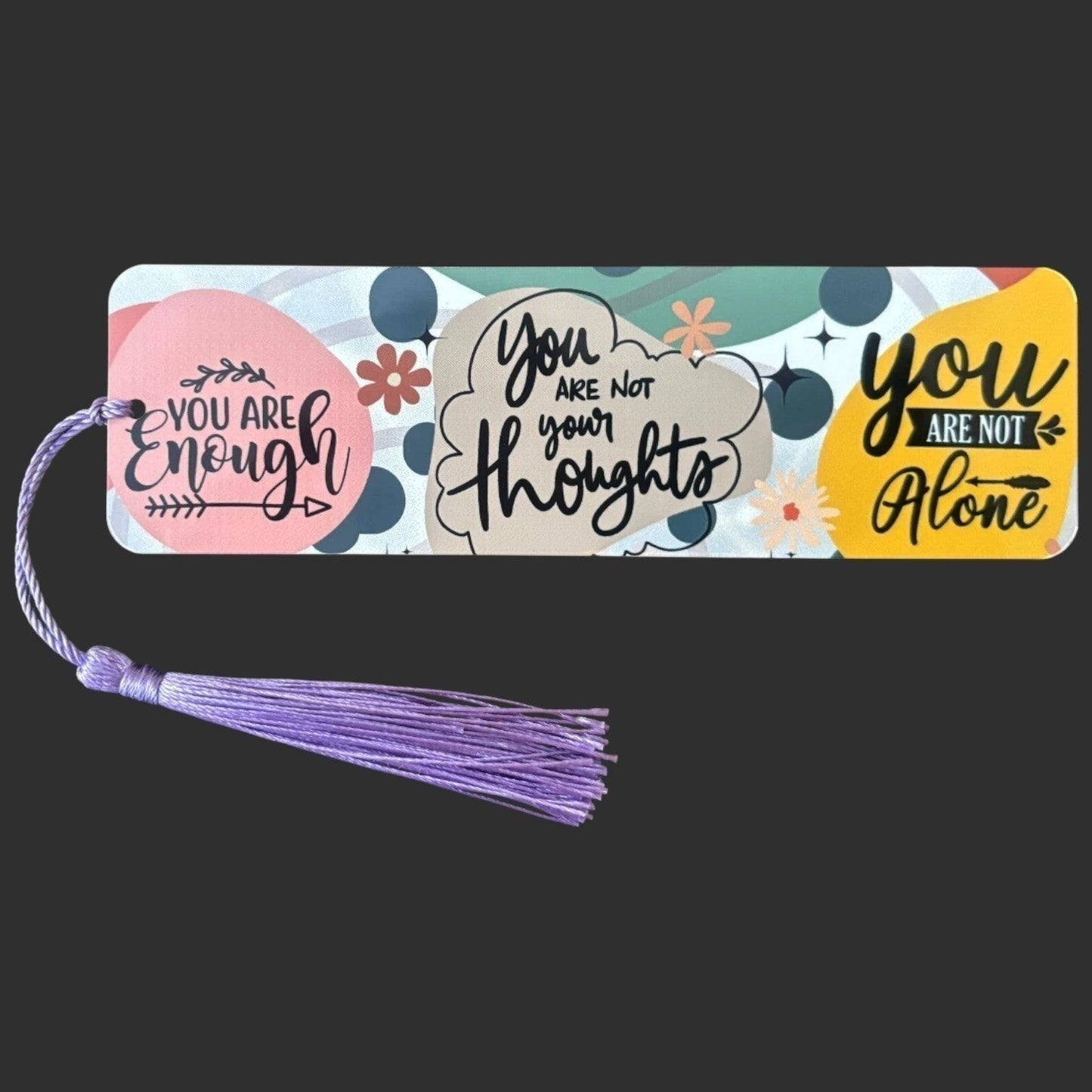 Illustrated Solutions Store metal affirmation bookmark with colorful motivational quotes and a purple tassel.