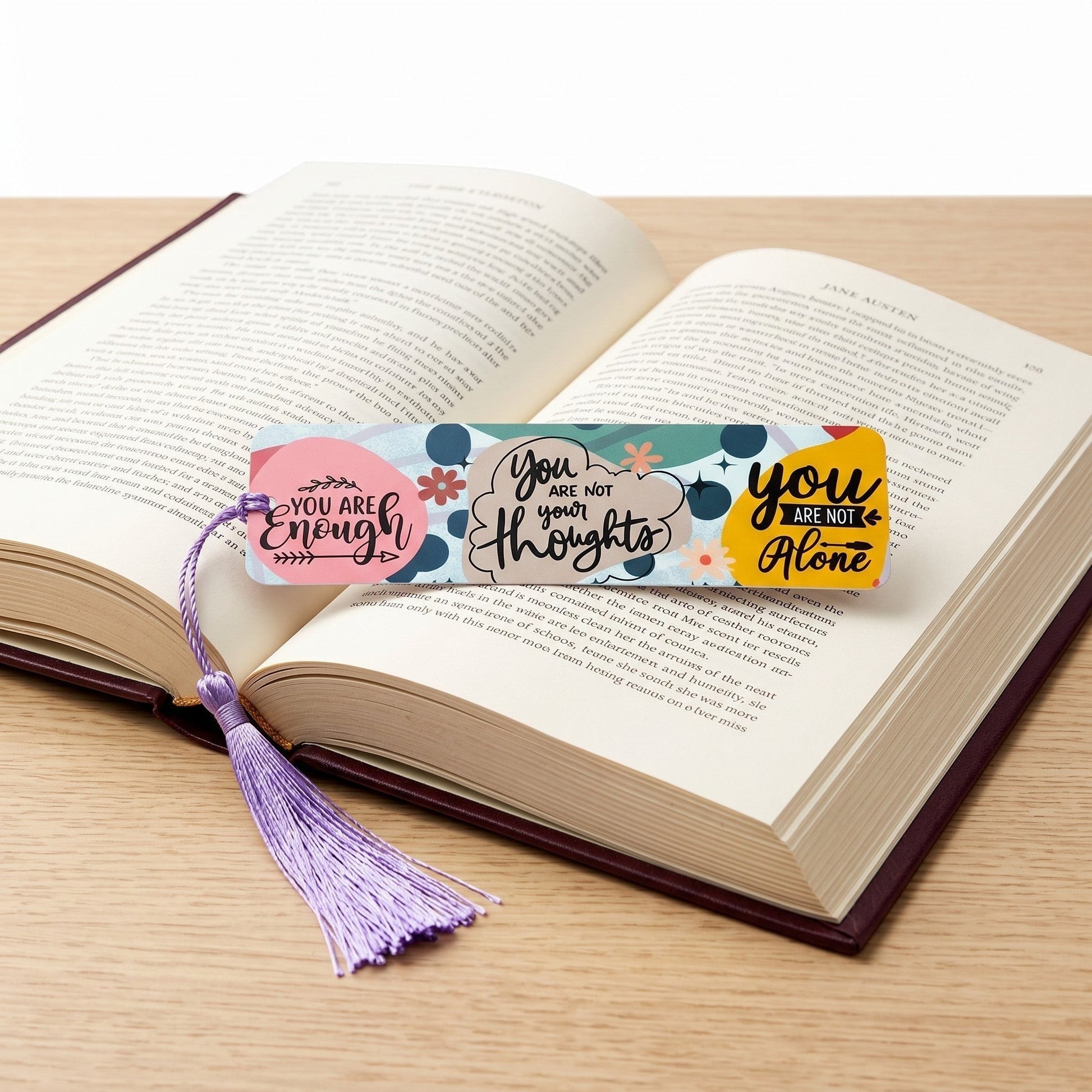 Illustrated Solutions Store metal affirmation bookmark with colourful positive quotes and a purple tassel in a book.