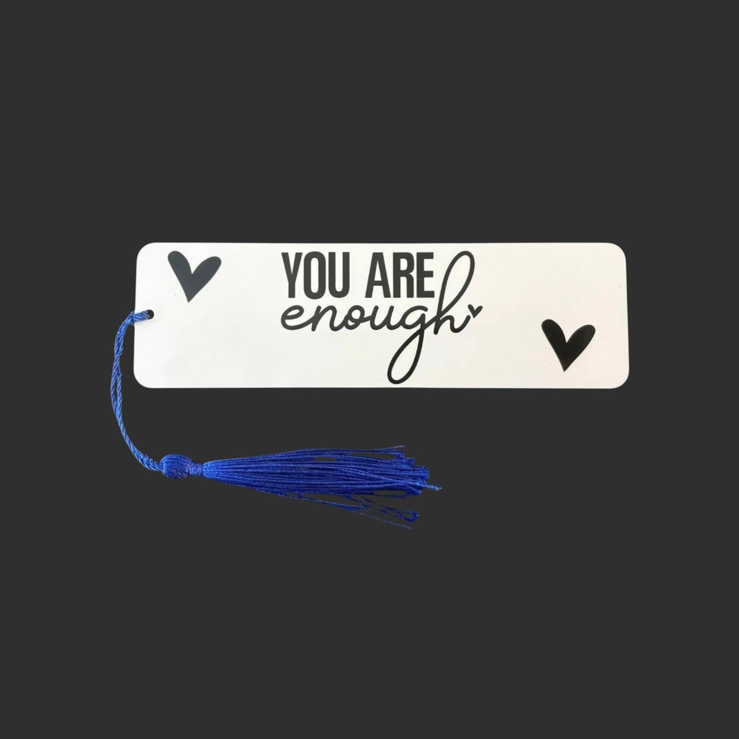 Illustrated Solutions Store metal bookmark with You Are Enough text and black hearts, featuring a blue tassel.