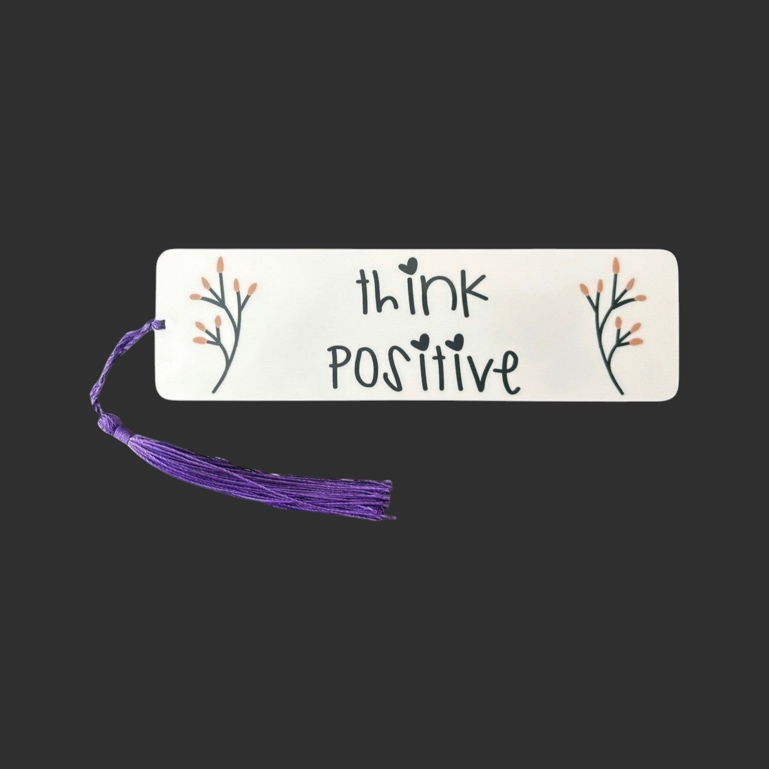 Illustrated Solutions Store metal bookmark with Think Positive text and floral accents and a purple tassel.