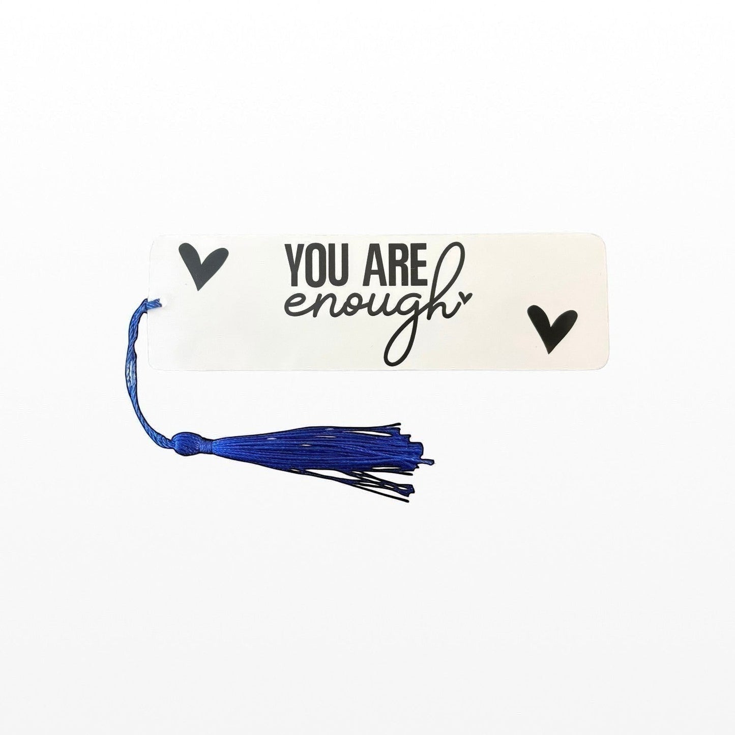 Illustrated Solutions Store white metal bookmark with You Are Enough text and black hearts, featuring a blue tassel.