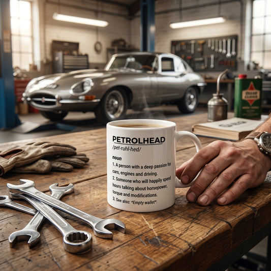 Illustrated Solutions Store white ceramic mug featuring a humorous Petrolhead definition in a garage setting