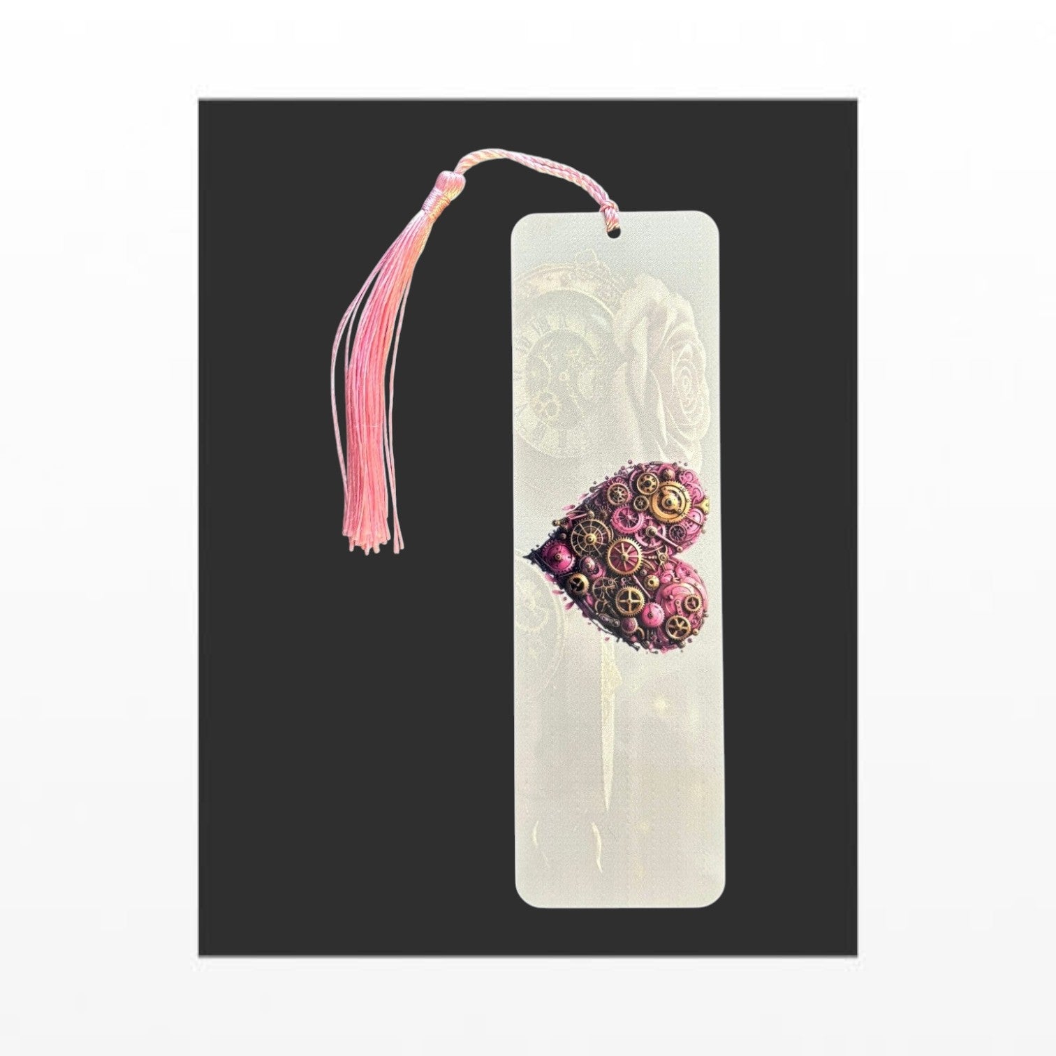 Illustrated Solutions Store pink heart steampunk metal bookmark with intricate gear details and a matching pink tassel. Vertical view