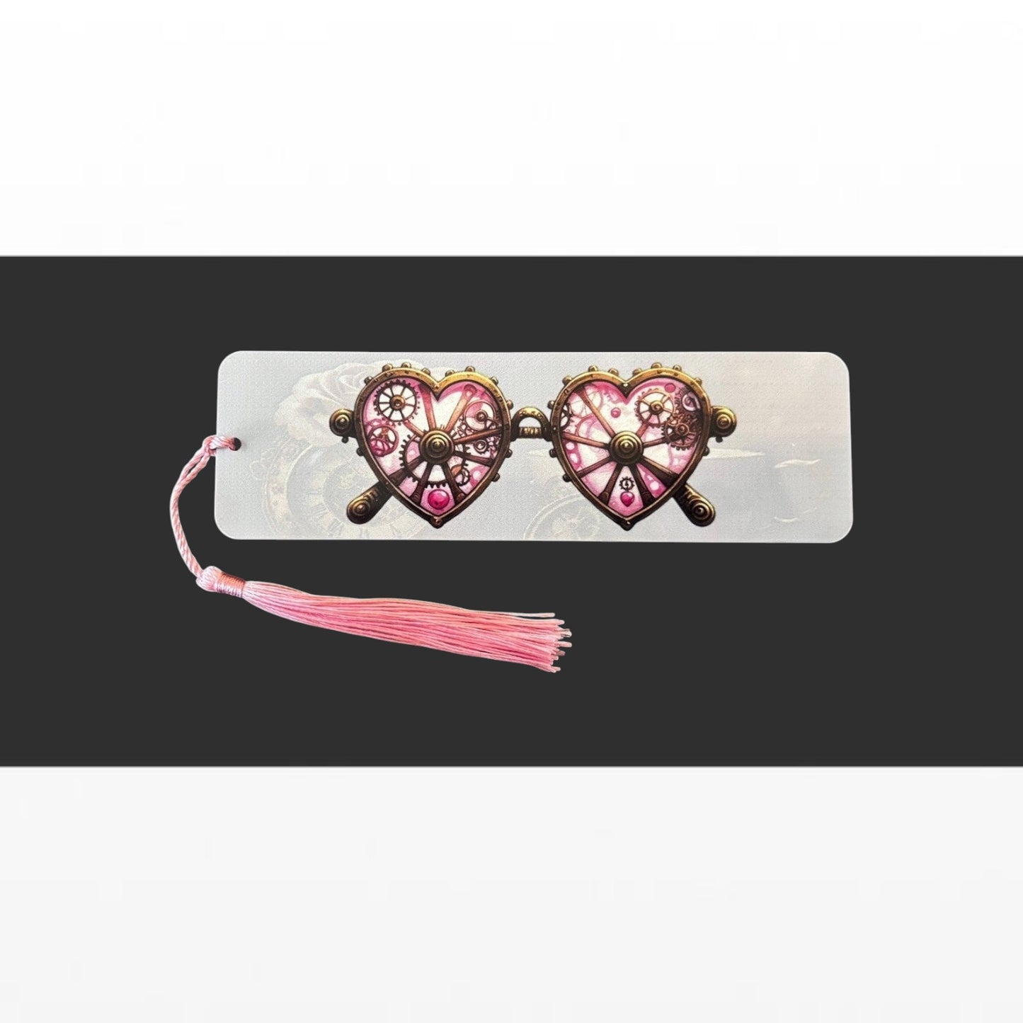 Illustrated Solutions Store metal bookmark featuring pink steampunk heart-shaped glasses with a matching pink tassel.
