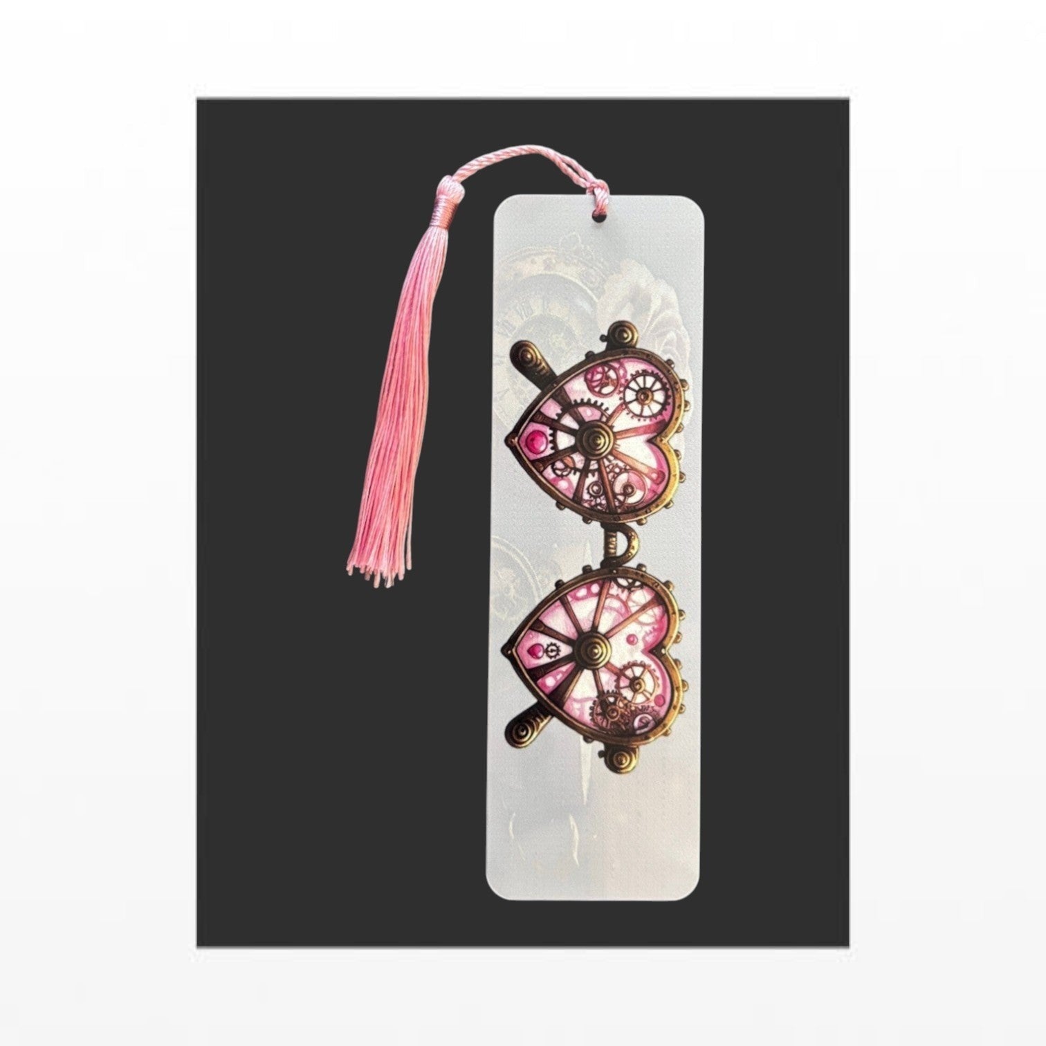 Illustrated Solutions Store metal bookmark featuring pink steampunk heart-shaped glasses with a matching pink tassel. Vertical view
