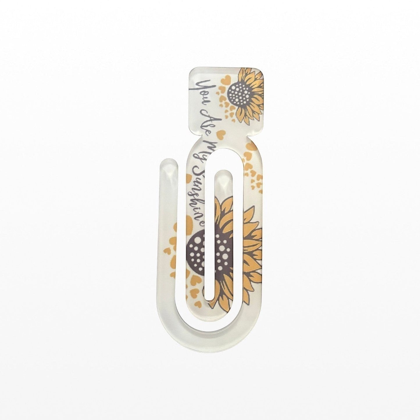 Illustrated Solutions Store acrylic book clip with sunflower design and You Are My Sunshine text on a white surface