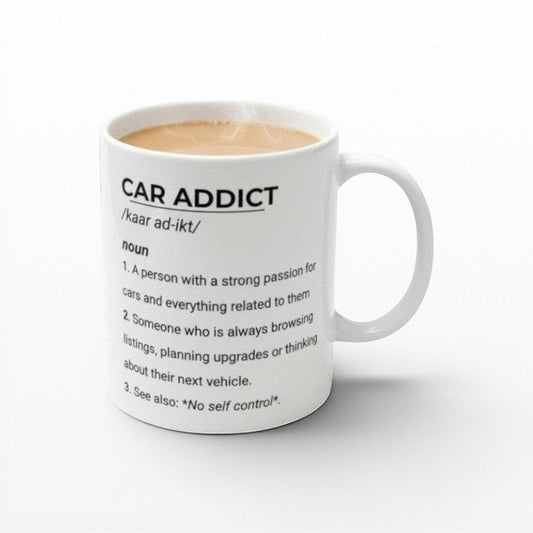 Illustrated Solutions Store white ceramic mug with black text defining 'Car Addict' as someone with a strong passion for cars and related activities.
