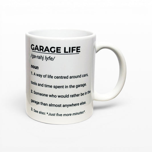 Illustrated Solutions Store white ceramic mug with black text defining "GARAGE LIFE" as a noun, perfect for car enthusiasts.