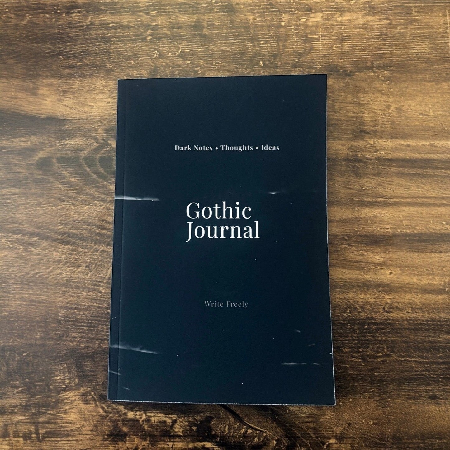 Illustrated Solutions Store Gothic Journal with 'Dark Notes • Thoughts • Ideas' and 'Write Freely' text on a dark navy cover.